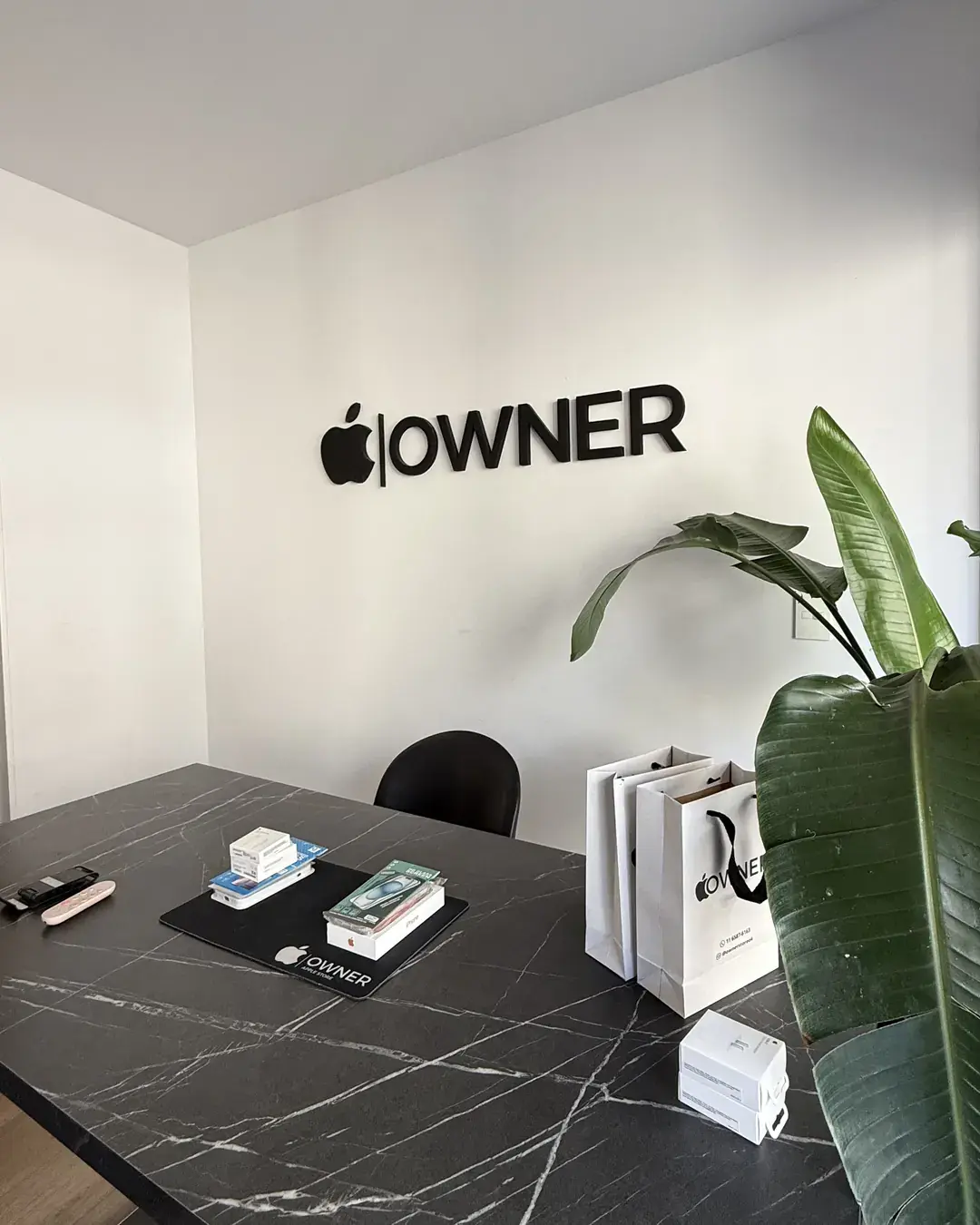 Mesa de atención frente al logo de Owner Store